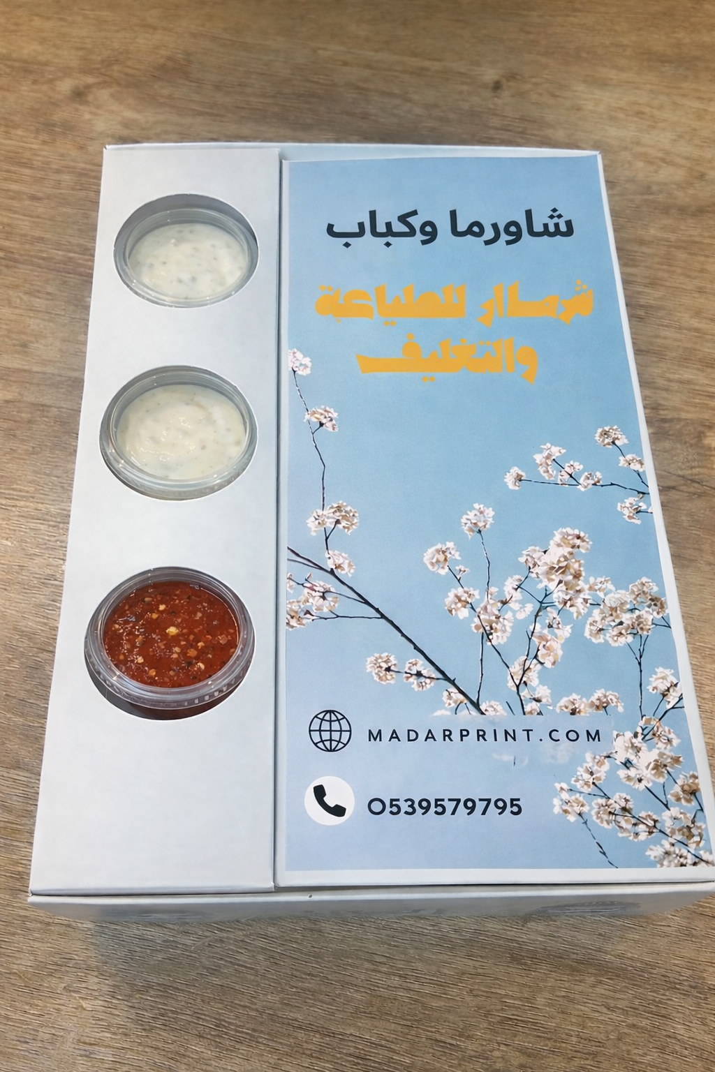 تغليف منتج بتصميم زهري ونص على سطح خشبي