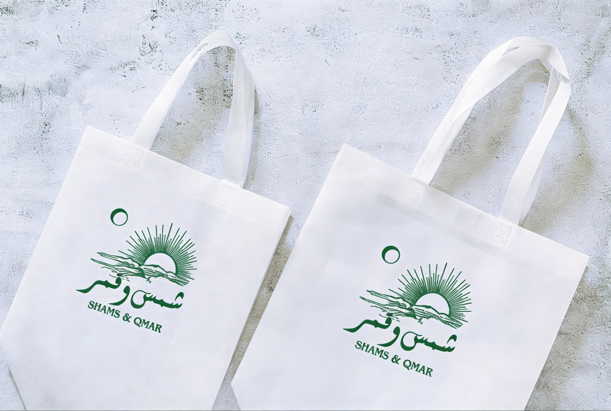 Two white tote bags with green branding on a light gray background