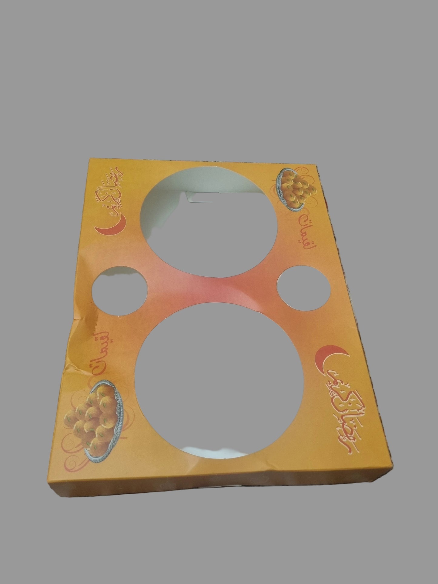 Orange packaging with white circular items on a patterned fabric background