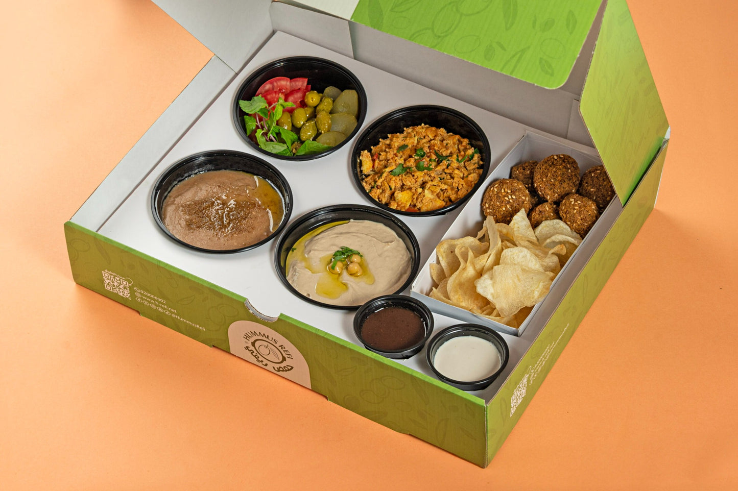 Assorted small dishes in a green box on an orange background