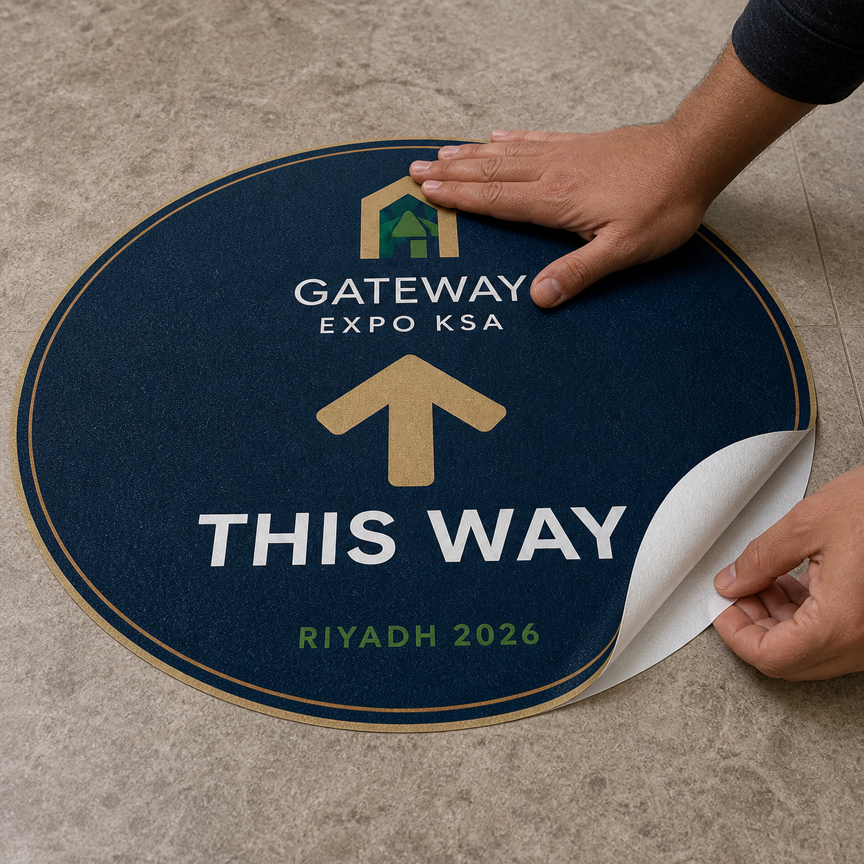 Custom directional floor sticker being applied to a stone floor with its textured laminate visible