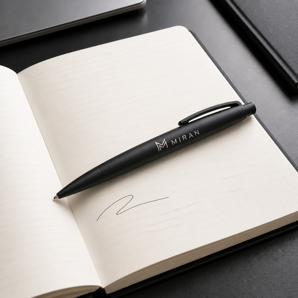 Custom printed black pen resting on an open notebook
