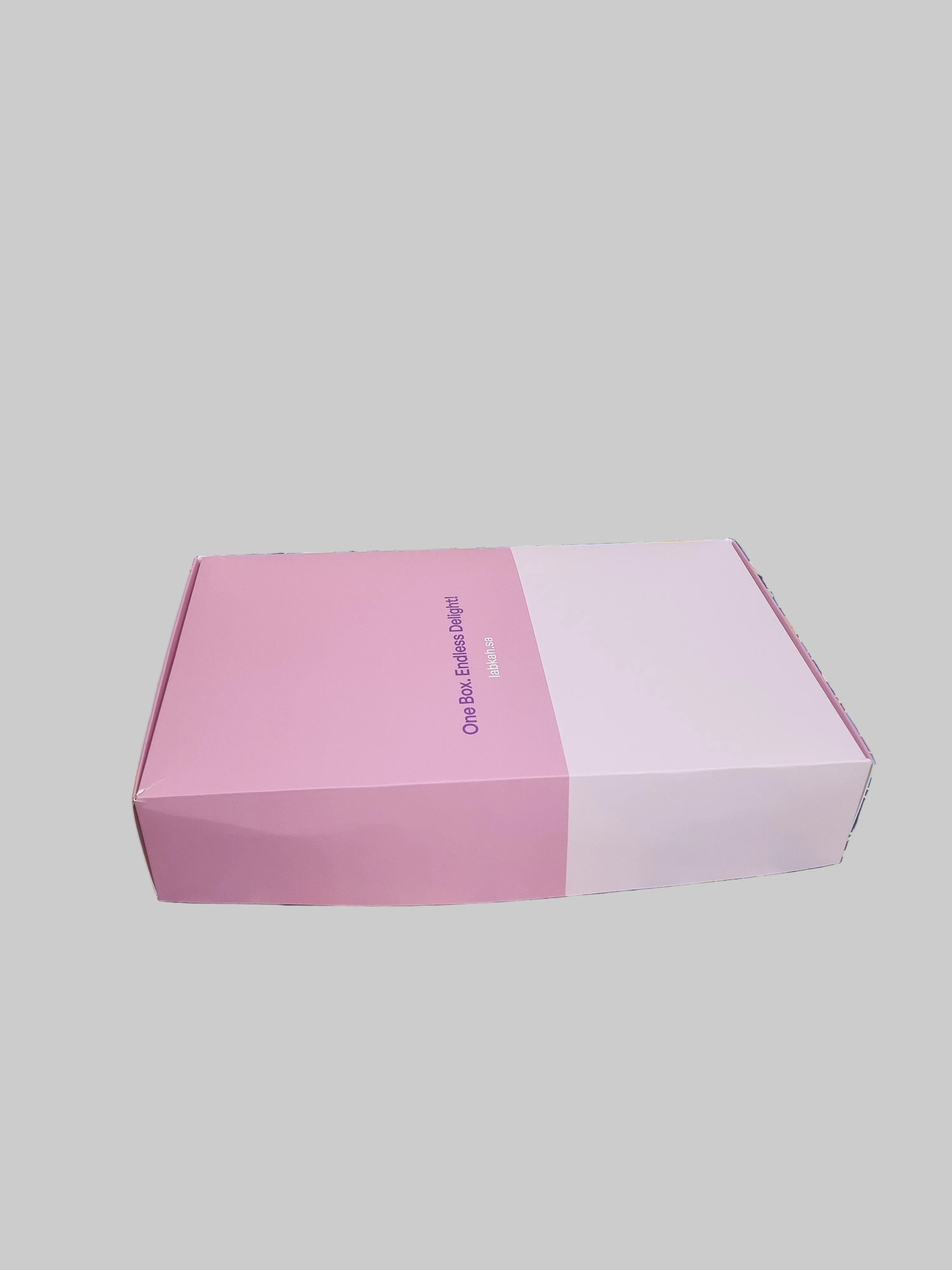 Colorful patterned box with a pink interior on a textured surface