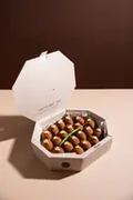 Open white octagonal gift box reference filled with assorted bite-size sweets